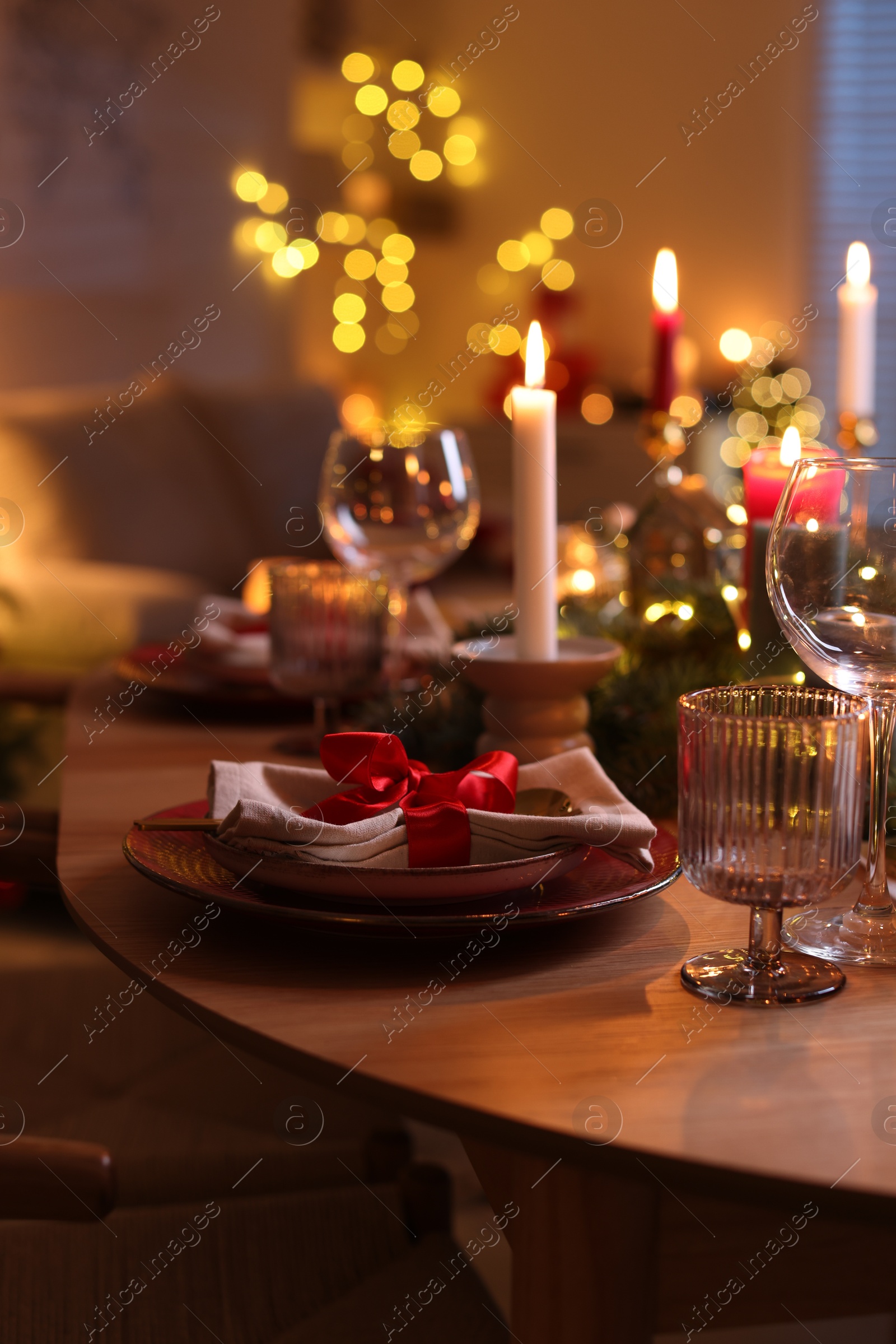 Photo of Festive table setting in room decorated for Christmas. Bokeh effect