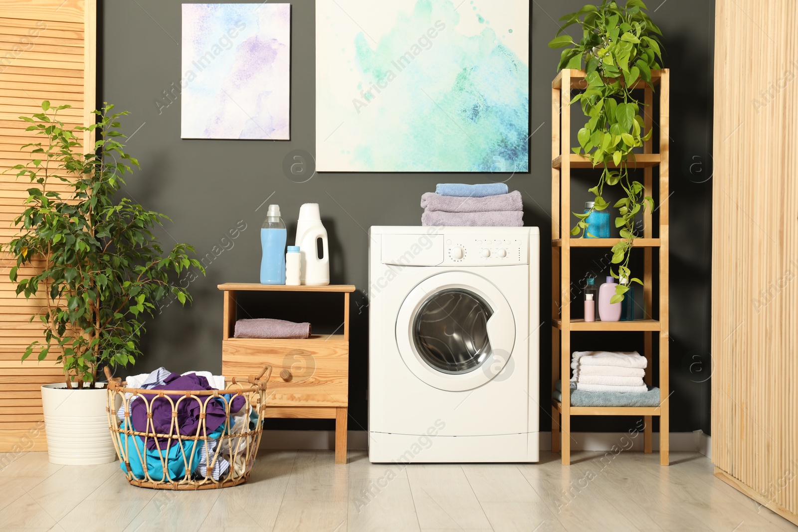 Photo of Washing machine, detergents and basket with laundry in room