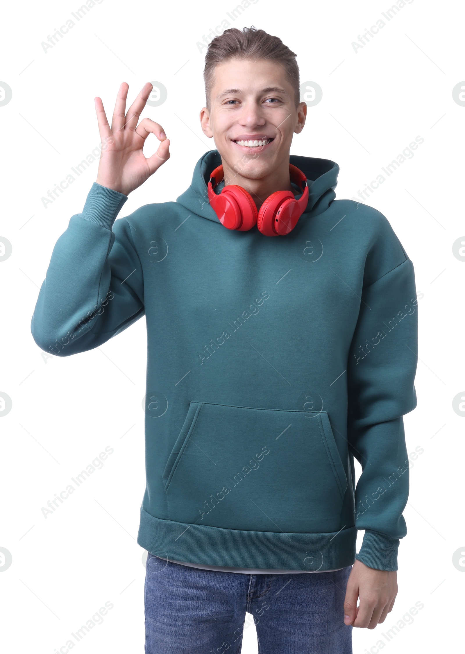 Photo of Happy young man with headphones showing OK gesture on white background