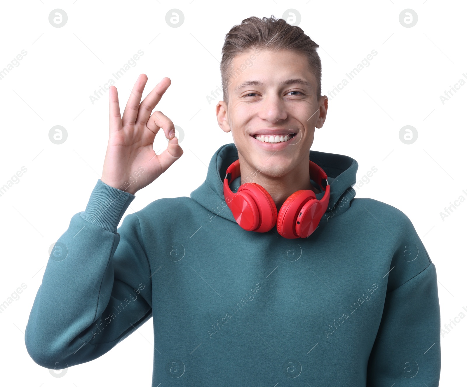 Photo of Happy young man with headphones showing OK gesture on white background