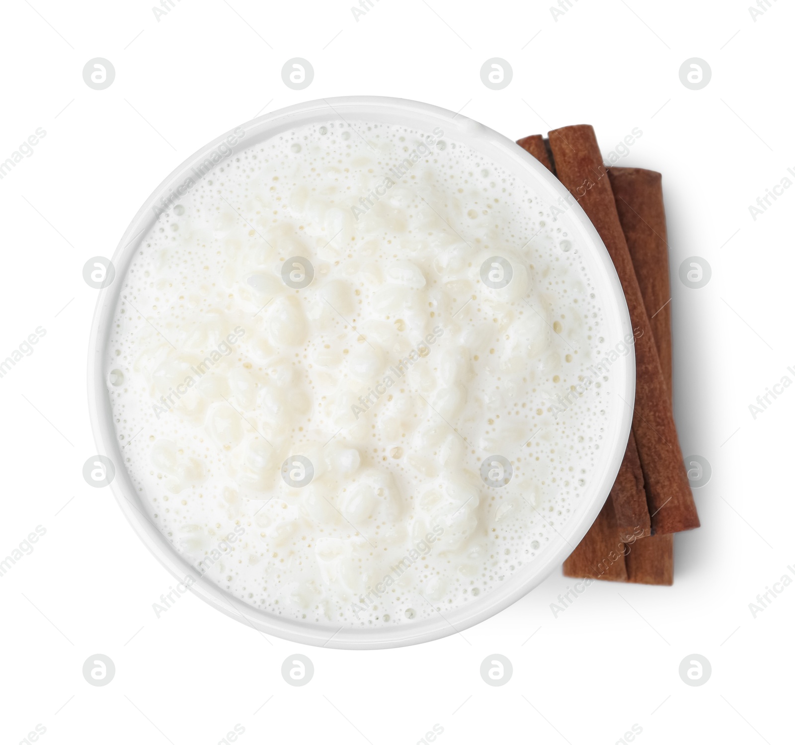 Photo of Delicious rice pudding with cinnamon sticks isolated on white, top view