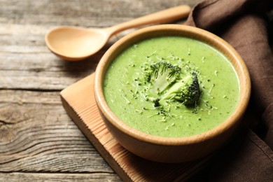 Photo of Delicious broccoli cream soup served on wooden table, closeup