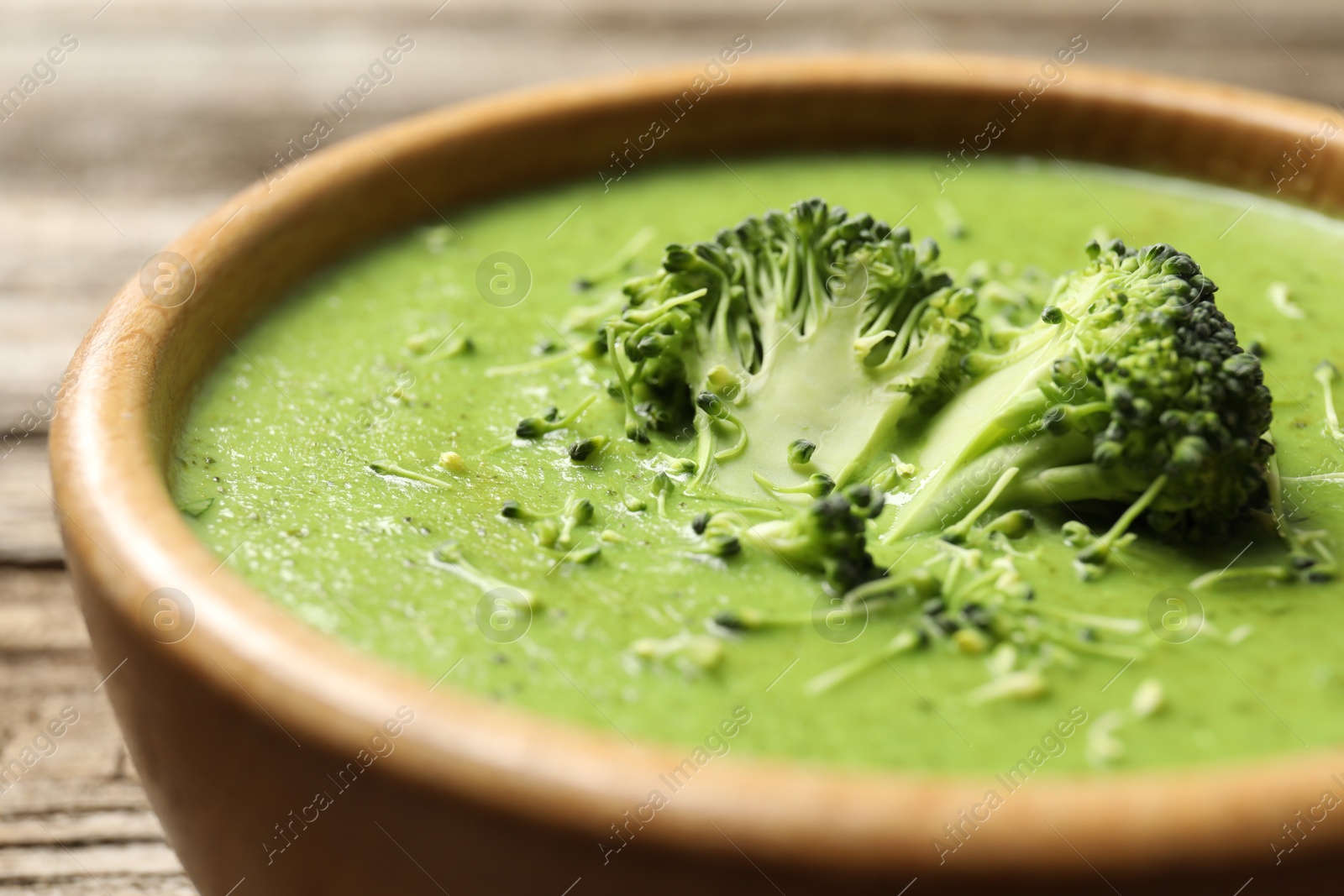 Photo of Delicious broccoli cream soup in bowl on table, closeup