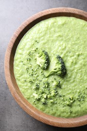 Photo of Delicious broccoli cream soup in bowl on grey table, top view