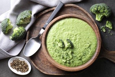 Photo of Delicious broccoli cream soup served on grey table, flat lay