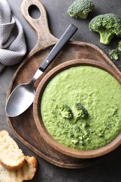 Photo of Delicious broccoli cream soup served on grey table, flat lay