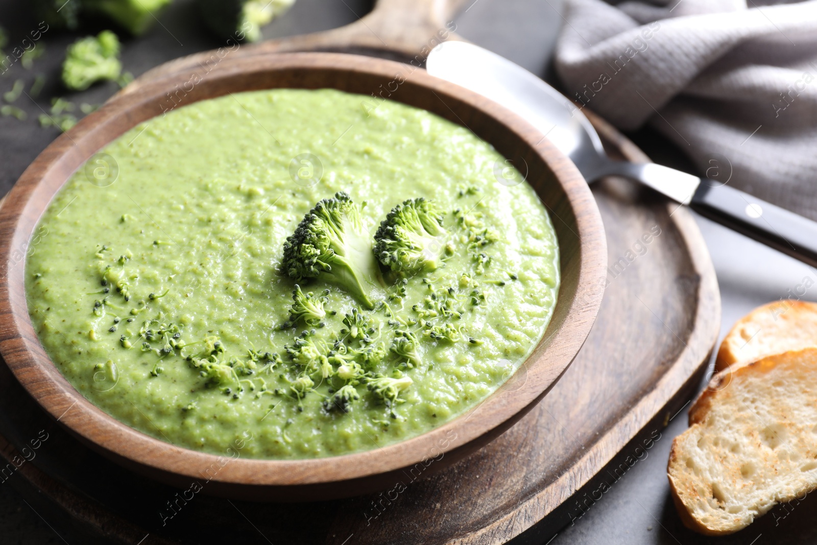 Photo of Delicious broccoli cream soup served on grey table, closeup