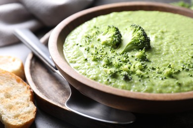 Photo of Delicious broccoli cream soup served on grey table, closeup