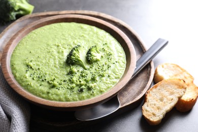 Photo of Delicious broccoli cream soup served on grey table, closeup