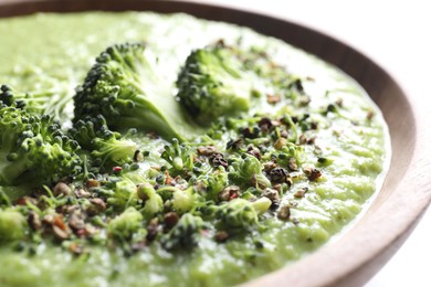 Photo of Delicious broccoli cream soup in bowl on white table, closeup