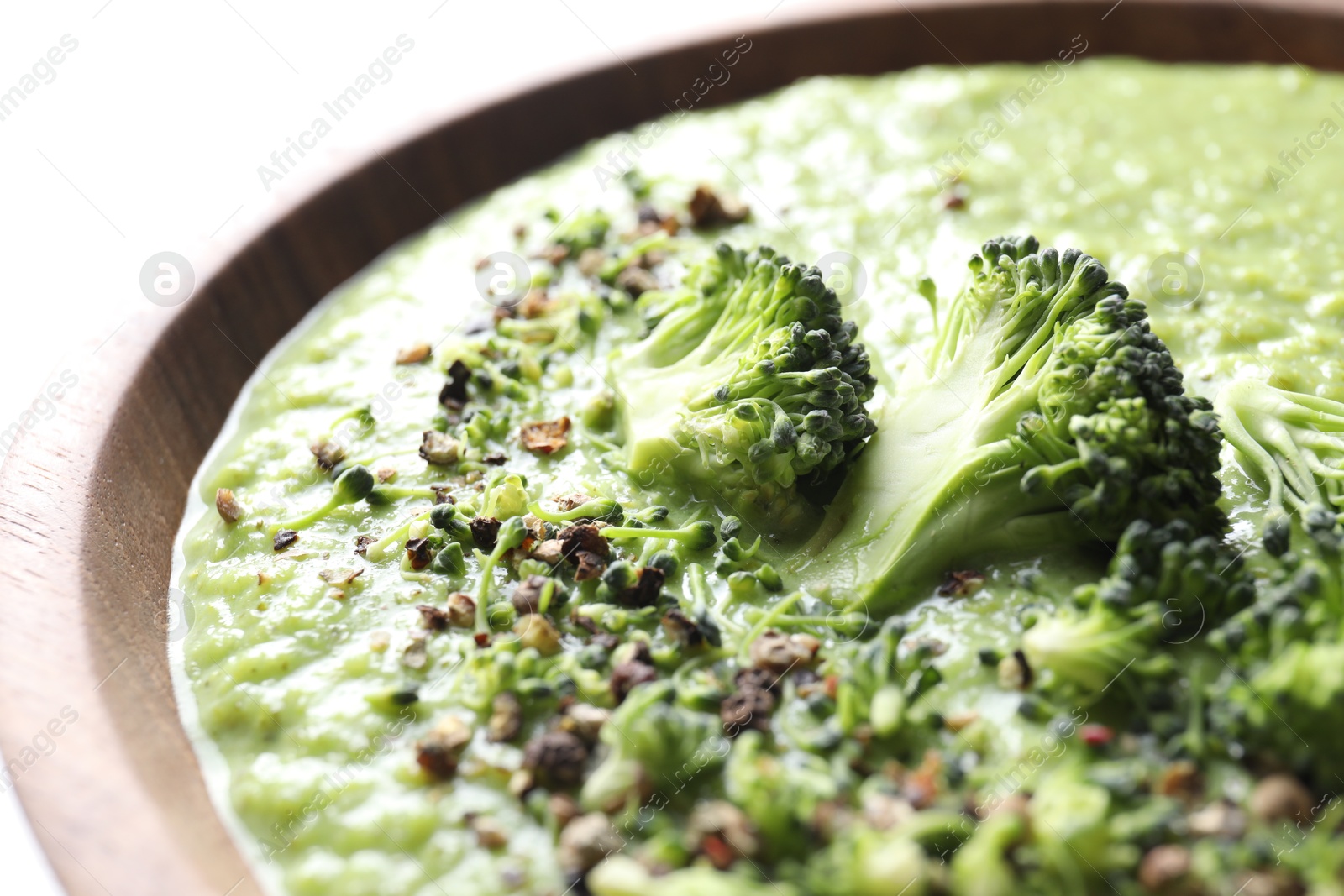 Photo of Delicious broccoli cream soup in bowl on white table, closeup