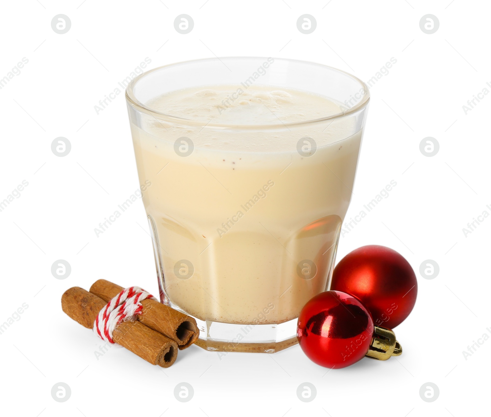 Photo of Tasty Christmas cocktail (eggnog) in glass, cinnamon and baubles isolated on white