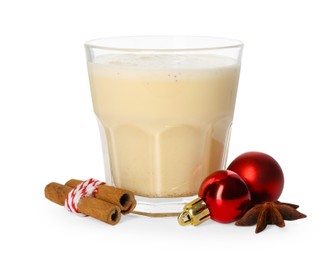 Photo of Tasty Christmas cocktail (eggnog) in glass, spices and baubles isolated on white