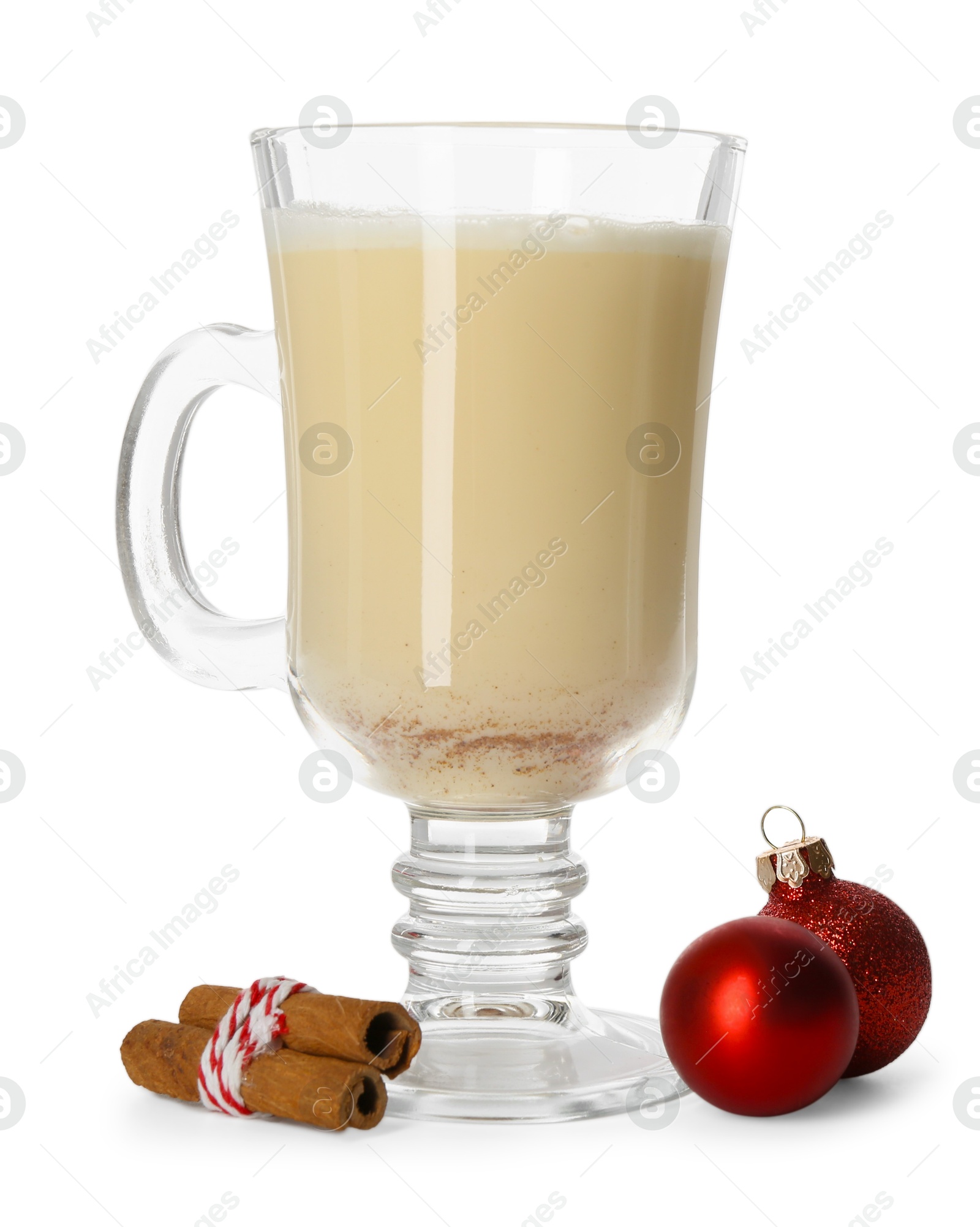 Photo of Tasty Christmas cocktail (eggnog) in glass, cinnamon and baubles isolated on white