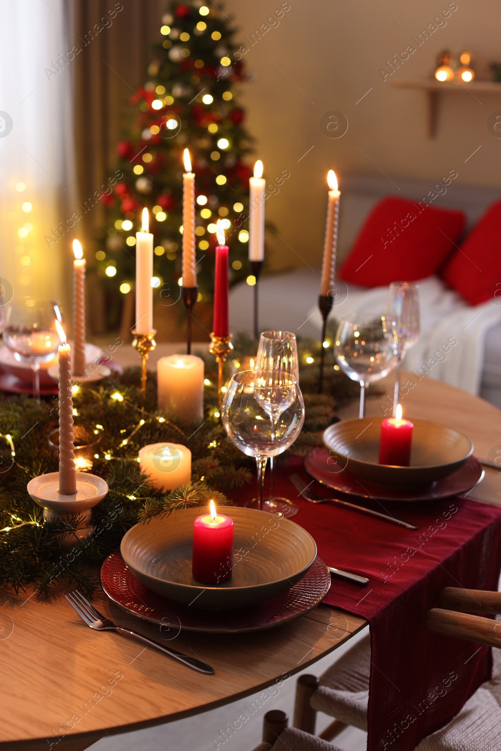 Photo of Festive table setting in room decorated for Christmas. Bokeh effect