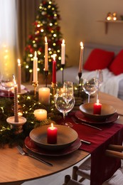 Photo of Festive table setting in room decorated for Christmas. Bokeh effect