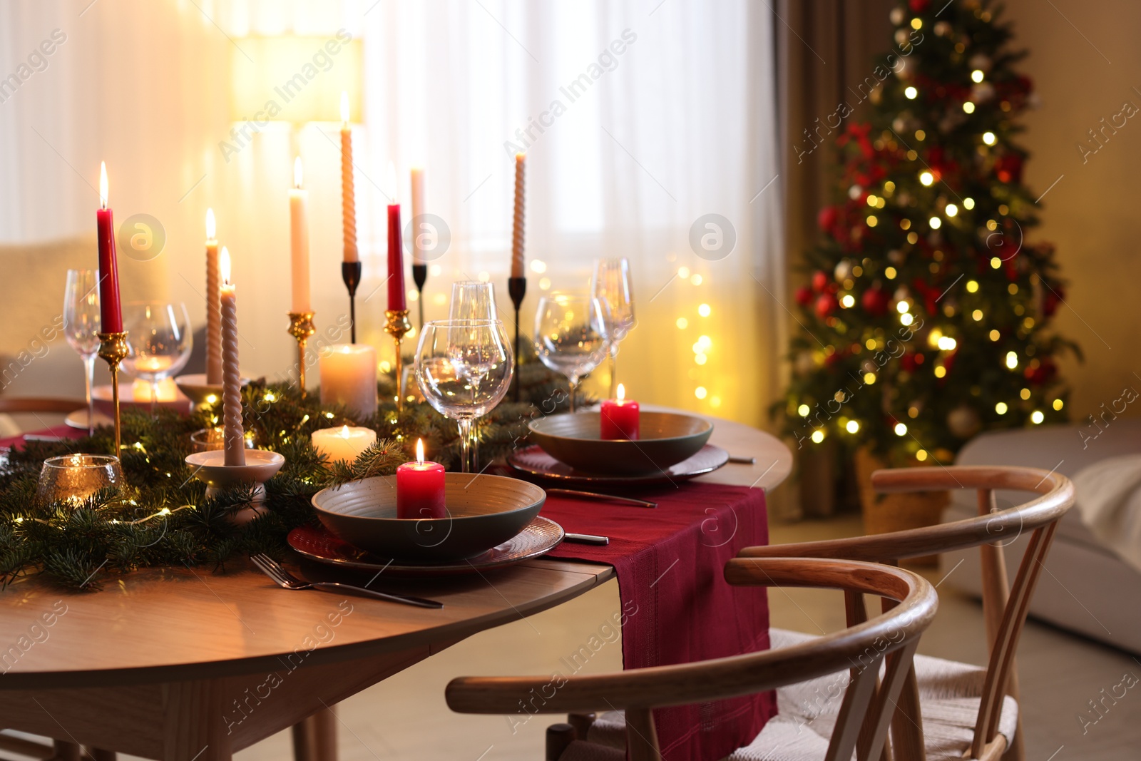 Photo of Festive table setting in room decorated for Christmas. Bokeh effect