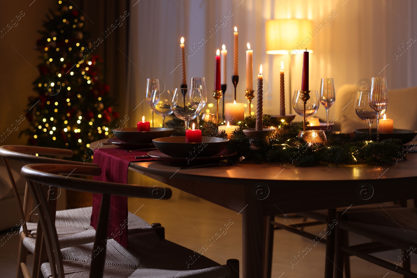 Photo of Festive table setting in room decorated for Christmas. Bokeh effect