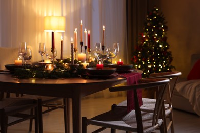 Photo of Festive table setting in room decorated for Christmas. Bokeh effect