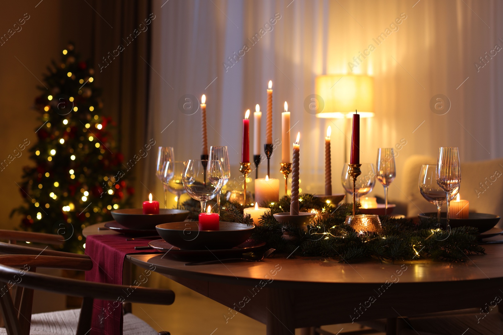 Photo of Festive table setting in room decorated for Christmas. Bokeh effect