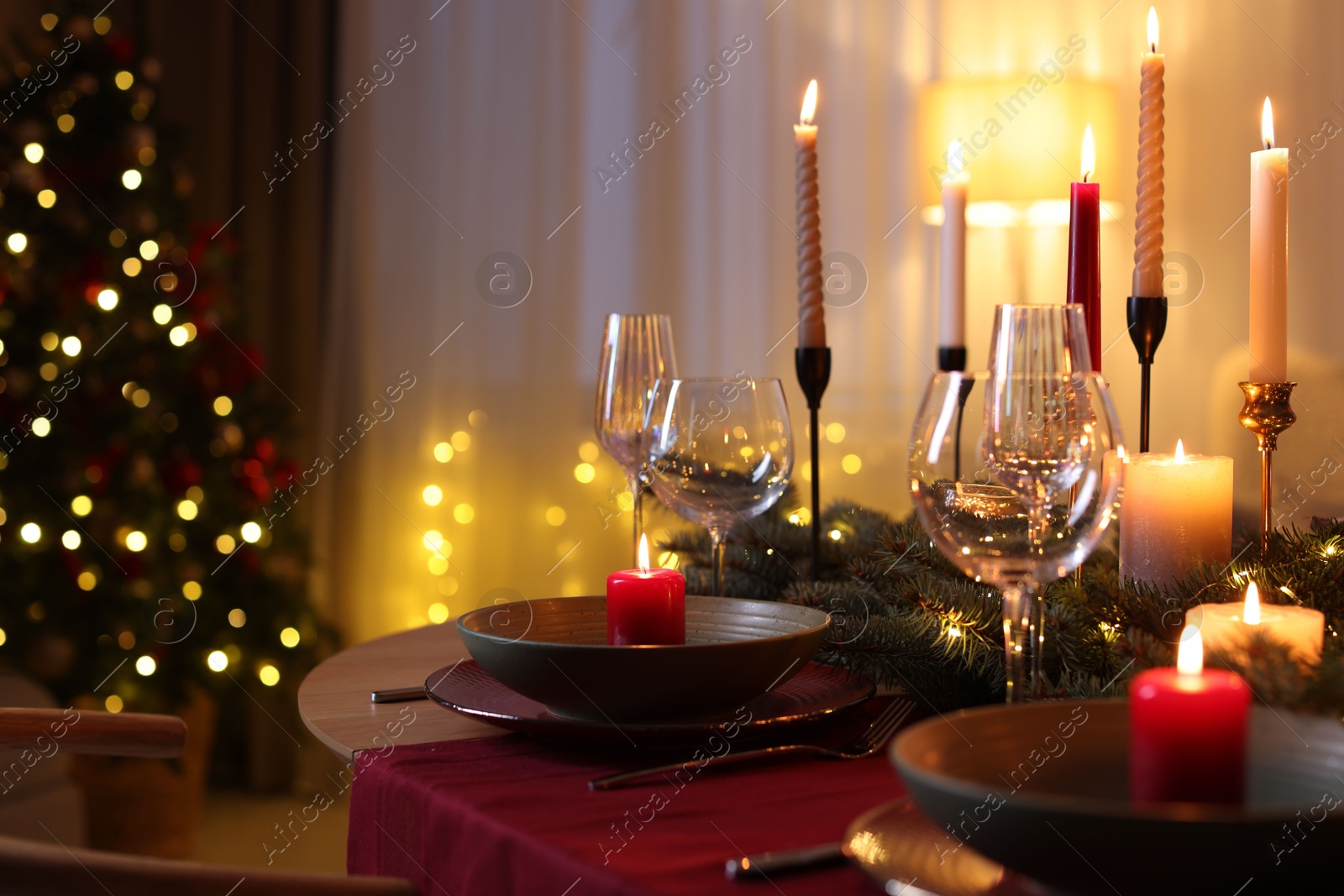 Photo of Festive table setting in room decorated for Christmas. Bokeh effect