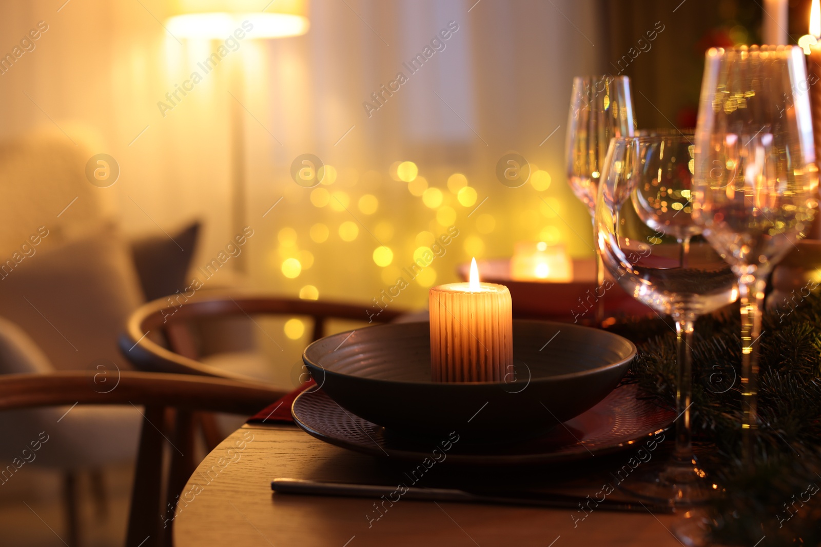 Photo of Festive table setting in room decorated for Christmas, closeup. Bokeh effect