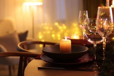 Photo of Festive table setting in room decorated for Christmas, closeup. Bokeh effect