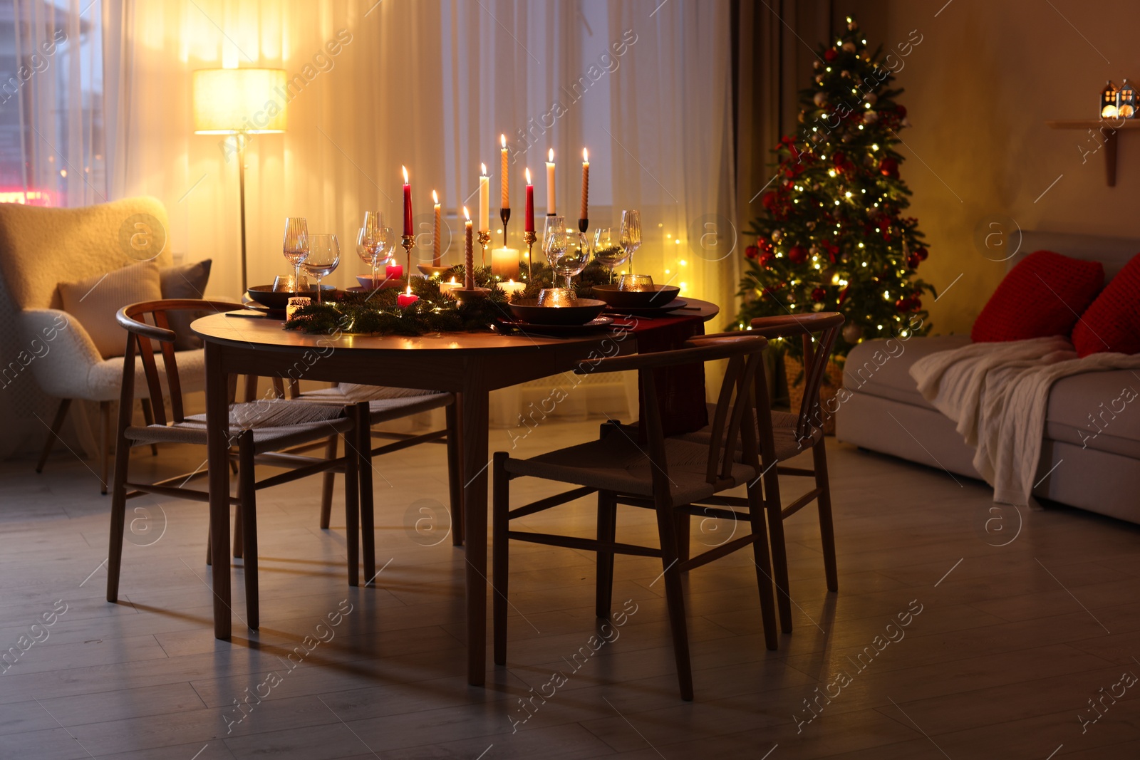 Photo of Festive table setting in room decorated for Christmas. Bokeh effect