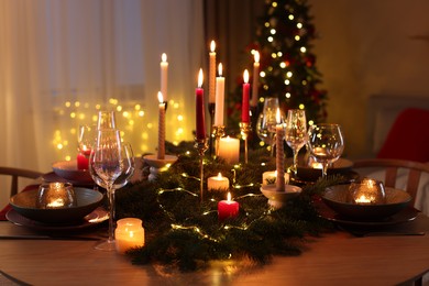 Photo of Festive table setting in room decorated for Christmas. Bokeh effect