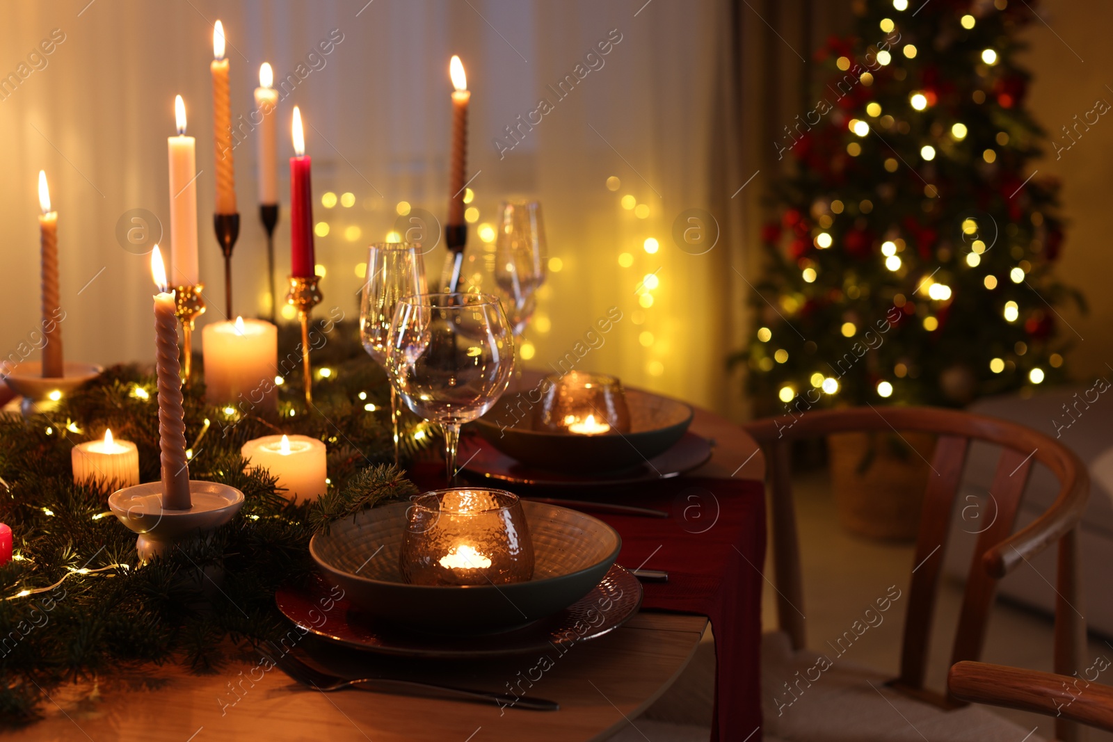 Photo of Festive table setting in room decorated for Christmas. Bokeh effect