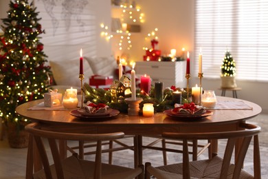 Photo of Festive table setting in room decorated for Christmas. Bokeh effect