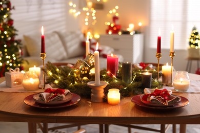 Photo of Festive table setting in room decorated for Christmas. Bokeh effect