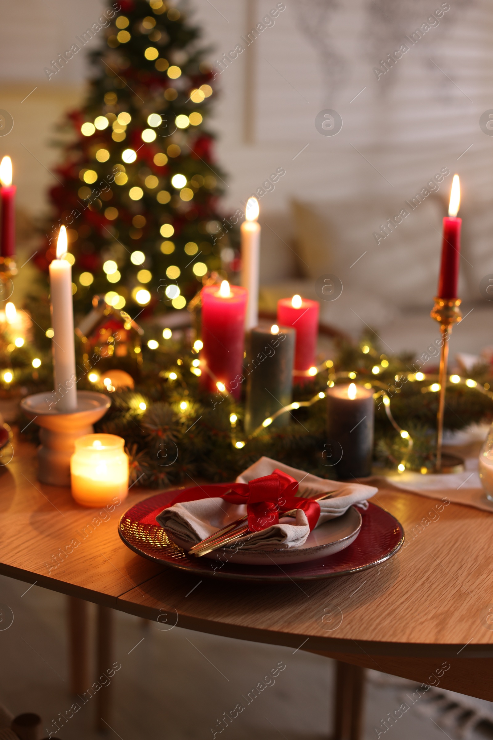 Photo of Festive table setting in room decorated for Christmas. Bokeh effect