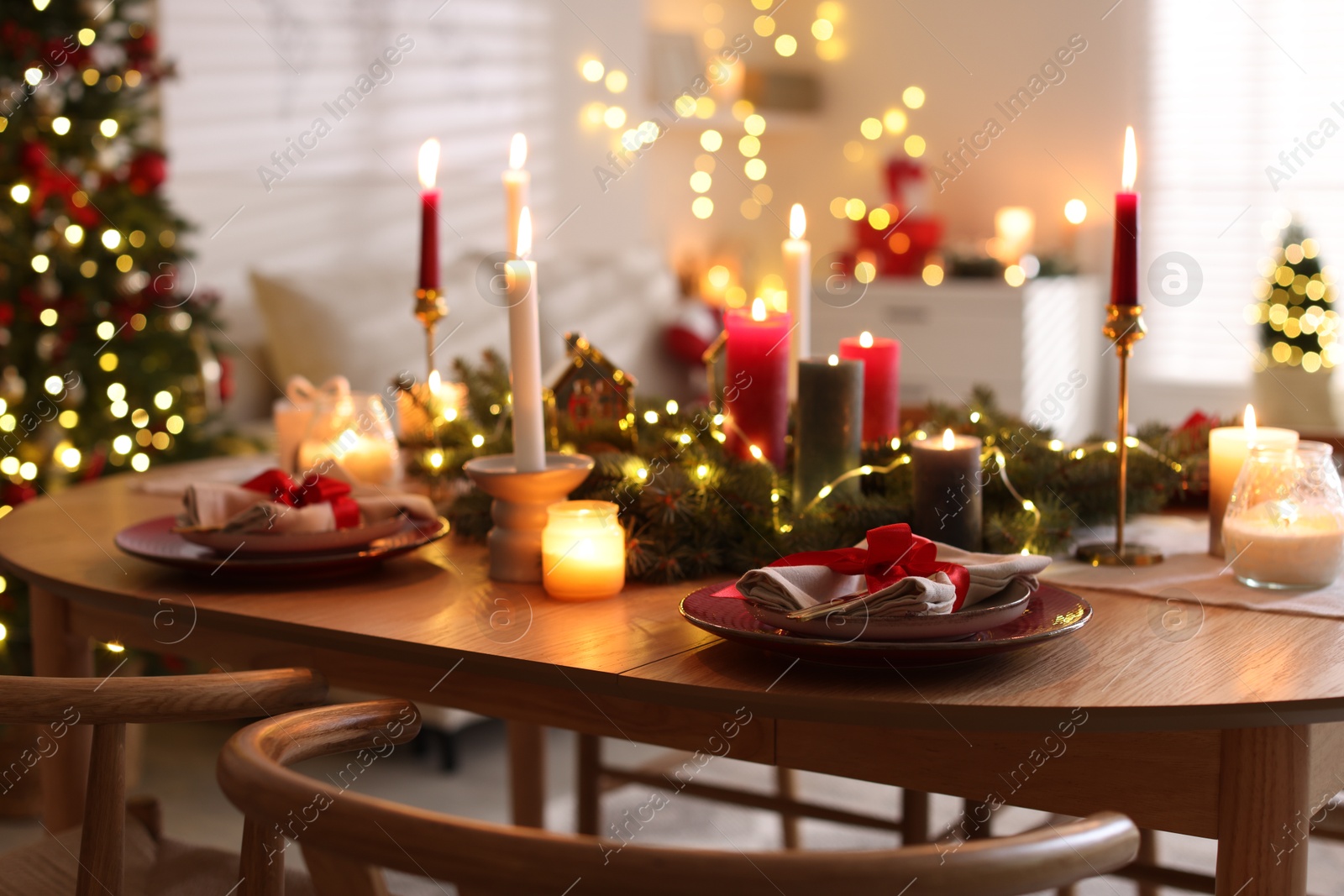 Photo of Festive table setting in room decorated for Christmas. Bokeh effect