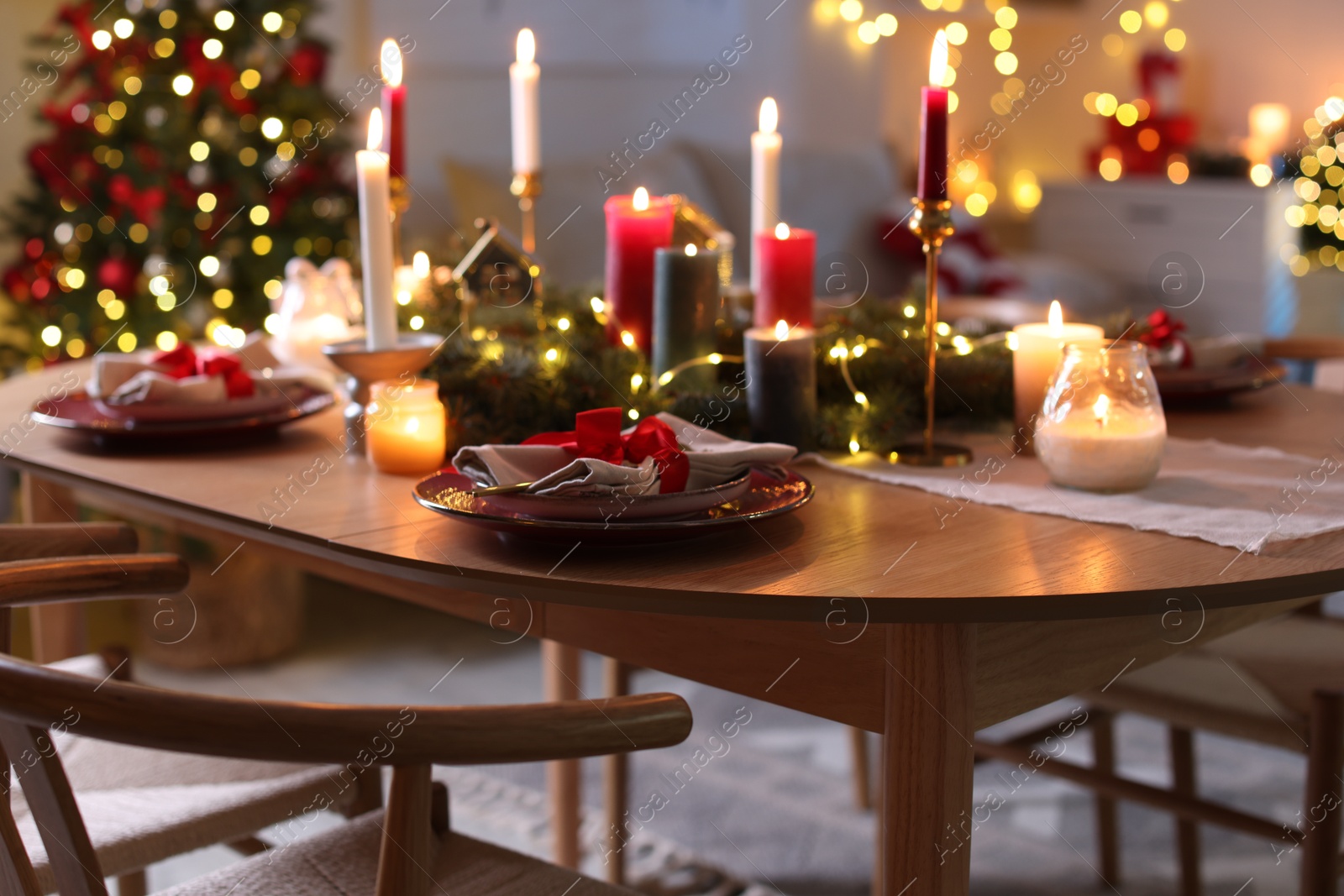 Photo of Festive table setting in room decorated for Christmas. Bokeh effect