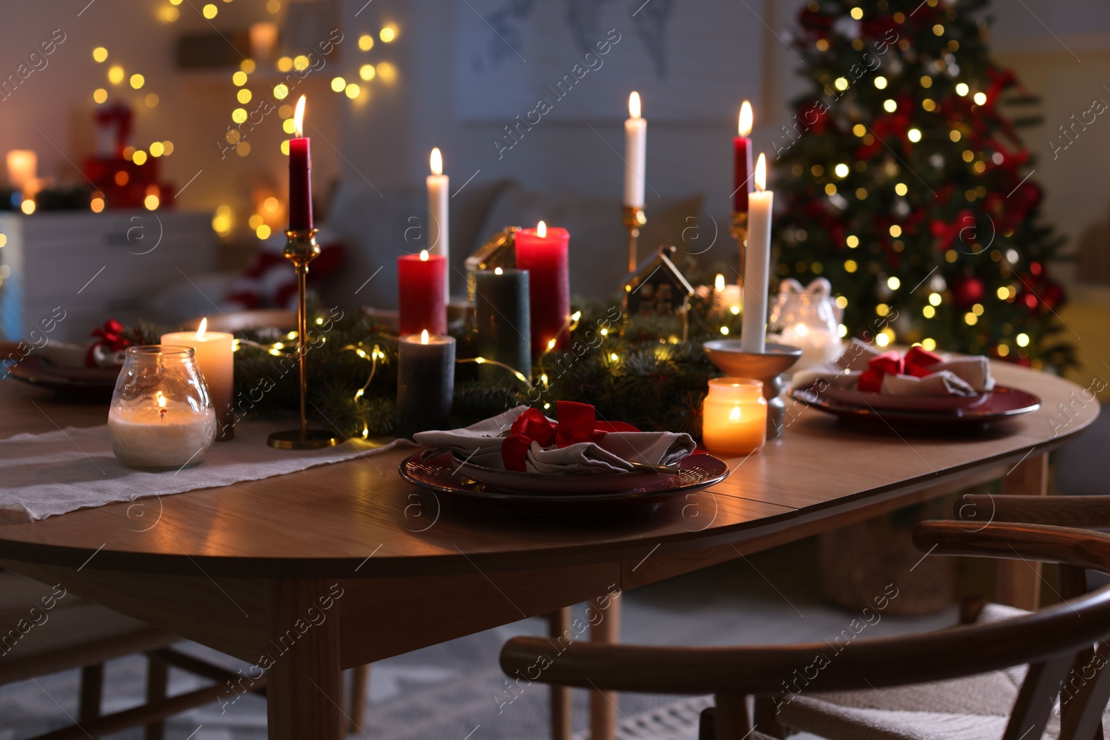 Photo of Festive table setting in room decorated for Christmas. Bokeh effect