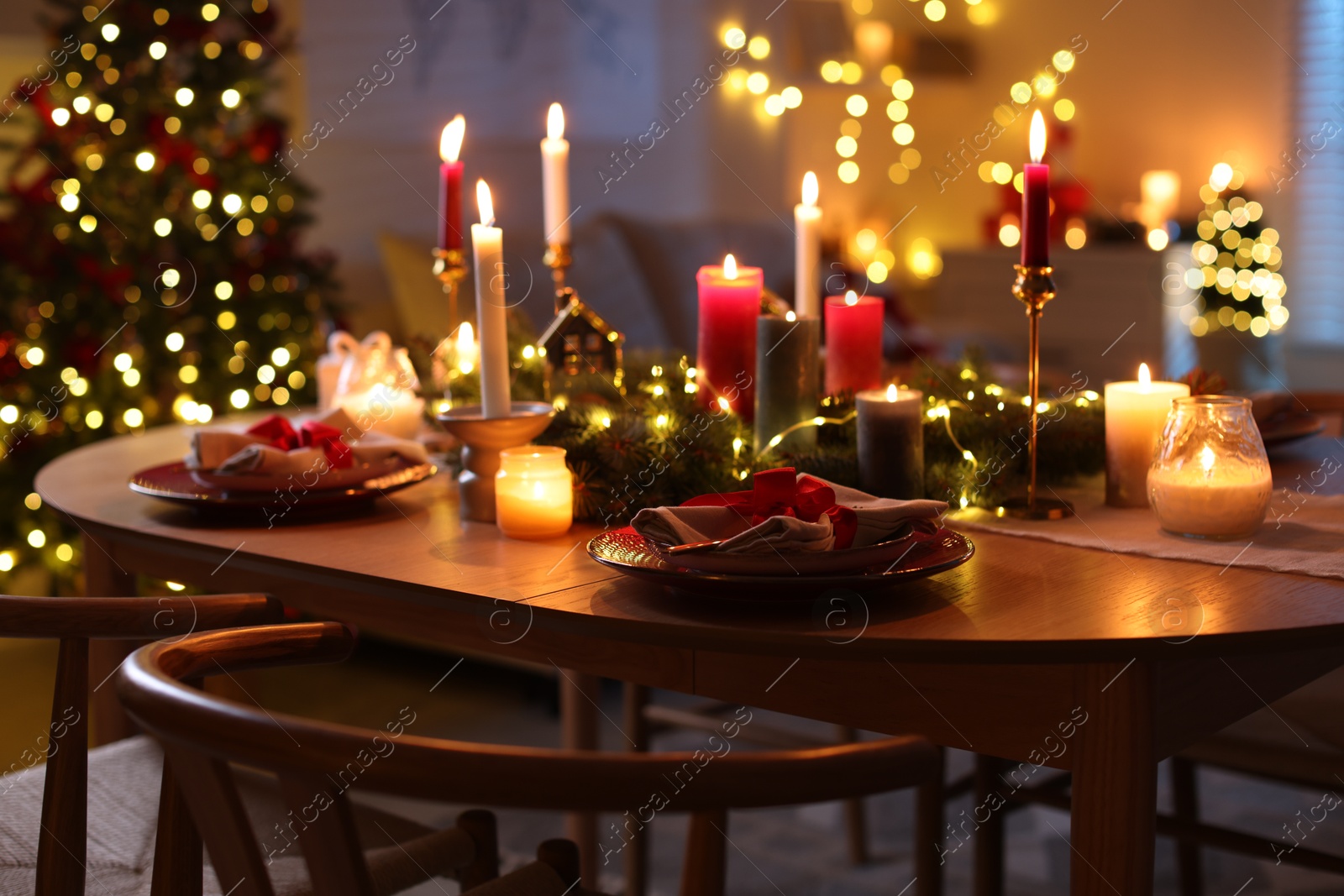 Photo of Festive table setting in room decorated for Christmas. Bokeh effect