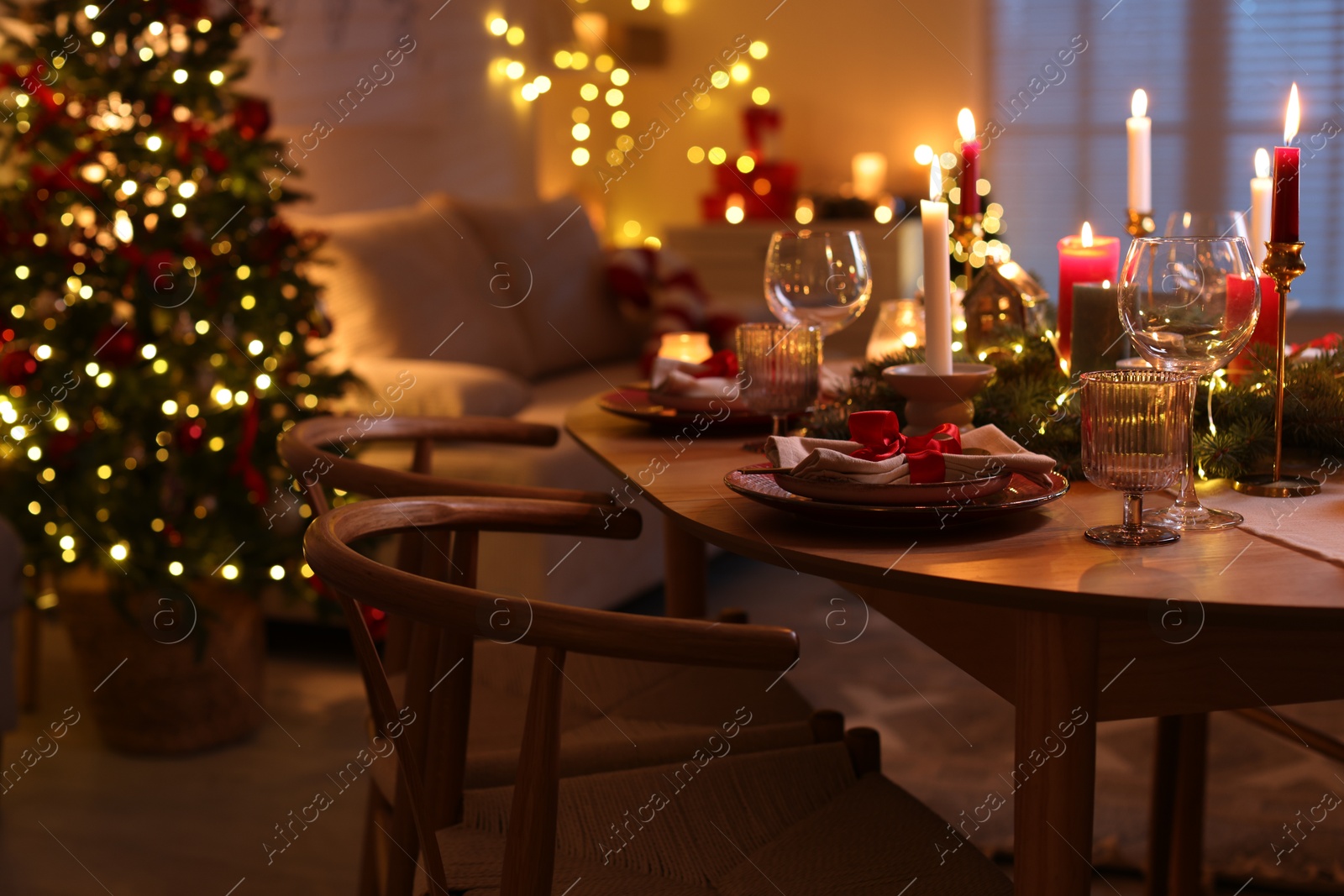 Photo of Festive table setting in room decorated for Christmas. Bokeh effect