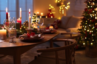 Photo of Festive table setting in room decorated for Christmas. Bokeh effect