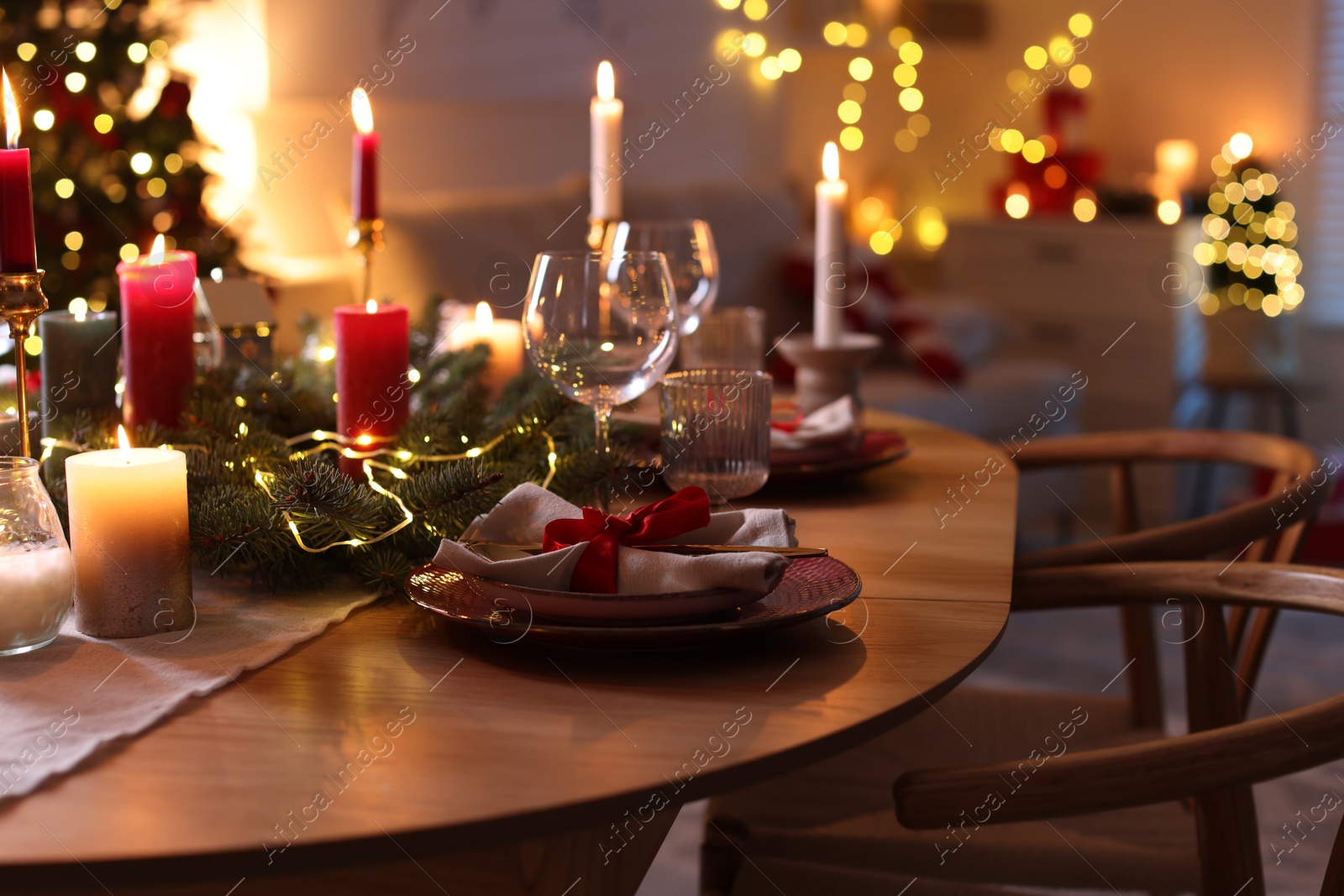 Photo of Festive table setting in room decorated for Christmas, closeup. Bokeh effect