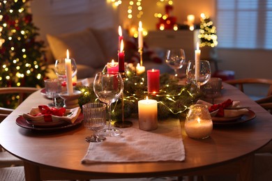 Photo of Festive table setting in room decorated for Christmas. Bokeh effect