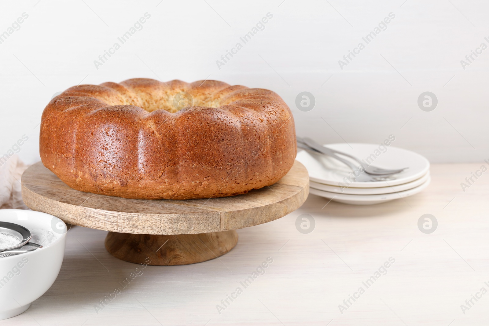 Photo of Freshly baked sponge cake served on white wooden table