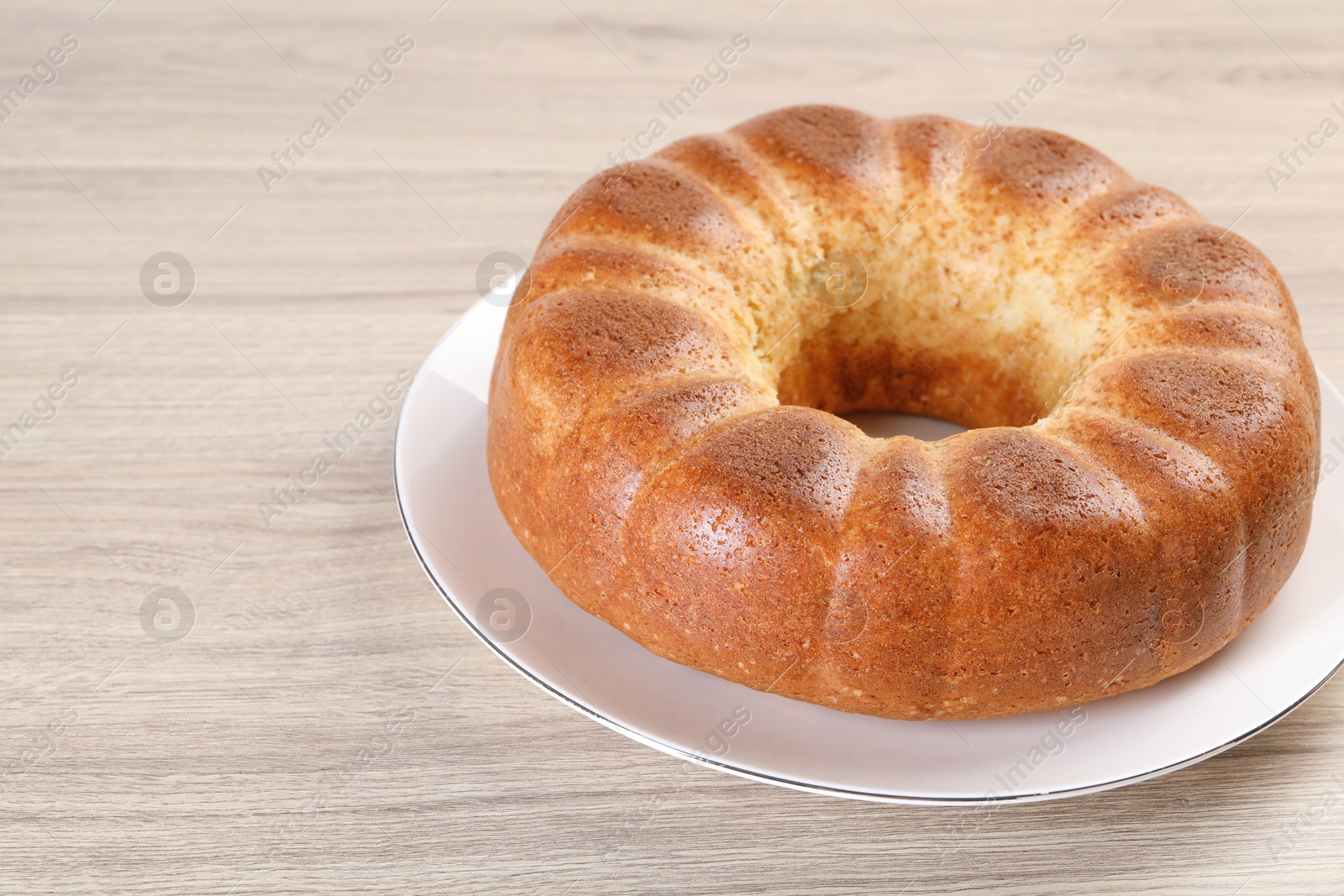 Photo of Freshly baked sponge cake on wooden table, closeup