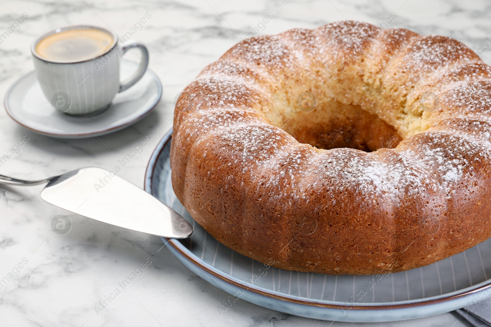 Photo of Freshly baked sponge cake, server and coffee on white marble table, closeup