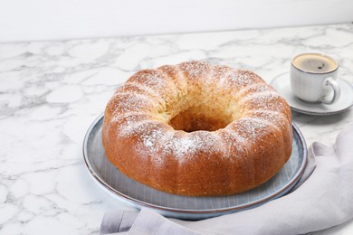 Photo of Freshly baked sponge cake and coffee on white marble table