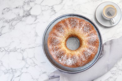 Photo of Freshly baked sponge cake and coffee on white marble table, top view. Space for text