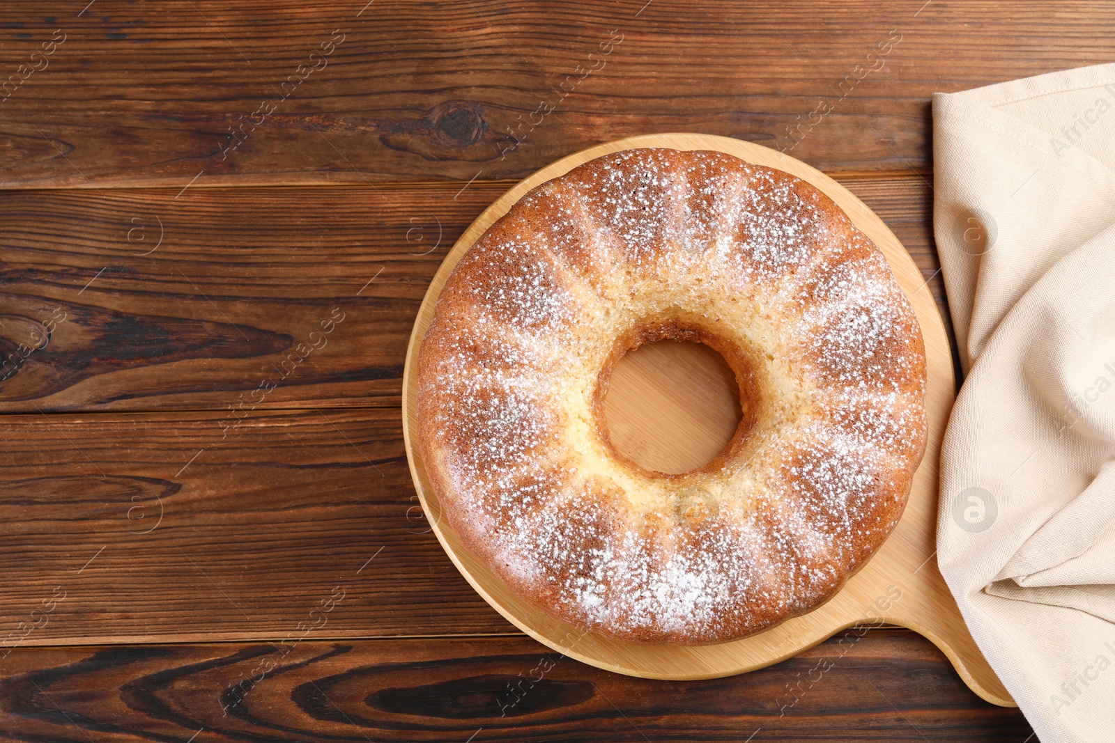 Photo of Freshly baked sponge cake on wooden table, top view. Space for text