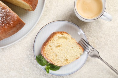 Photo of Piece of freshly baked sponge cake, mint and coffee on white textured table, top view