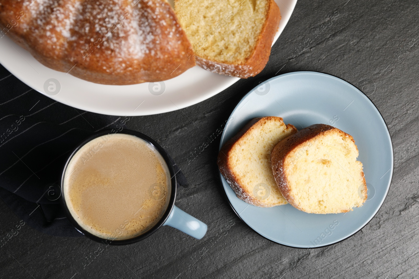 Photo of Freshly baked sponge cake and coffee on black table, top view