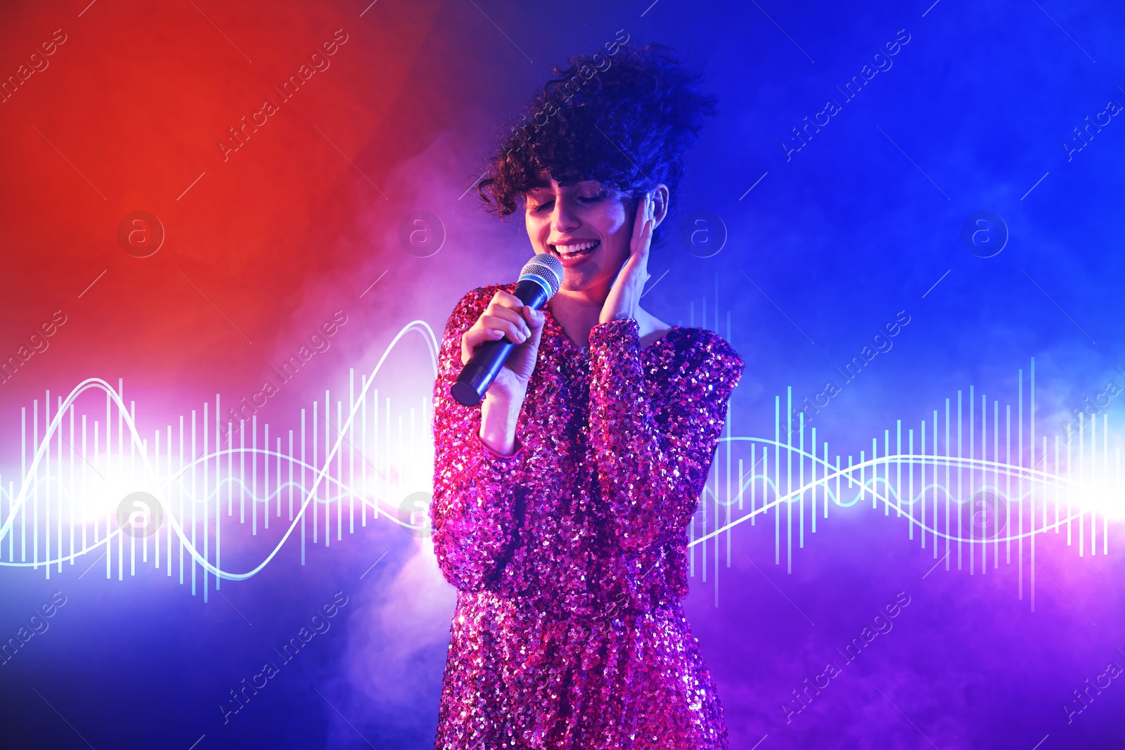 Image of Beautiful young woman with microphone singing on color background in neon lights and smoke. Sound waves